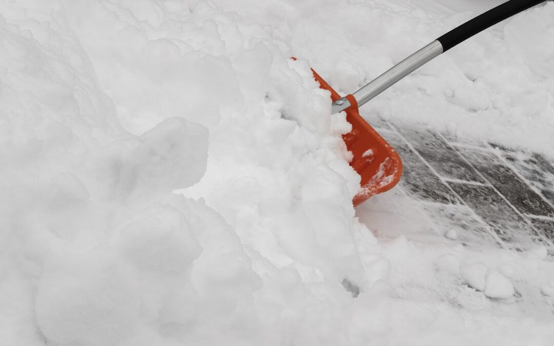 mit einer Schneeschaufel wird Schnee weggeräumt